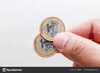 depositphotos_215619760-stock-photo-male-hand-holding-two-coins.jpg